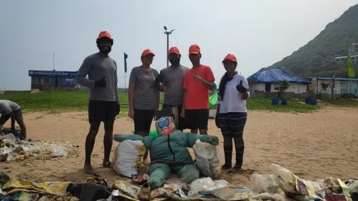 Team posing with a caricature created out of litter collected after one of the beach clean-up drives